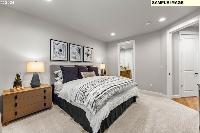 carpeted bedroom featuring ensuite bath