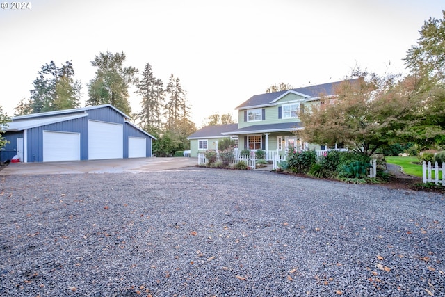 view of front of property featuring an outdoor structure, a porch, and a garage