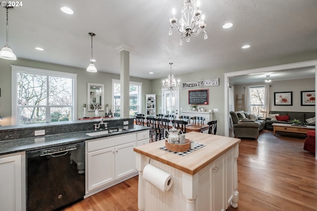 kitchen featuring white cabinets, pendant lighting, black dishwasher, and sink