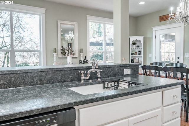 kitchen featuring white cabinetry, plenty of natural light, stainless steel dishwasher, and sink