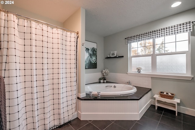 bathroom featuring tile patterned floors, plus walk in shower, and a textured ceiling