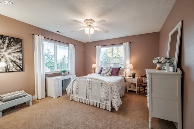 bedroom featuring light carpet, multiple windows, and ceiling fan