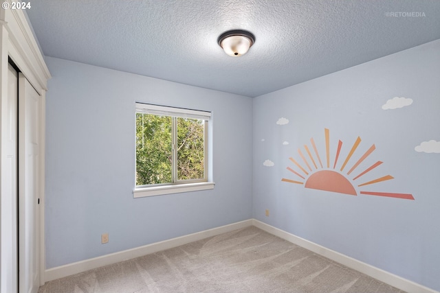 unfurnished room with carpet floors and a textured ceiling