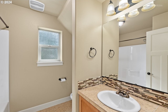 bathroom with vanity, toilet, tile patterned flooring, and backsplash