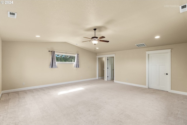 empty room with light colored carpet, lofted ceiling, and ceiling fan