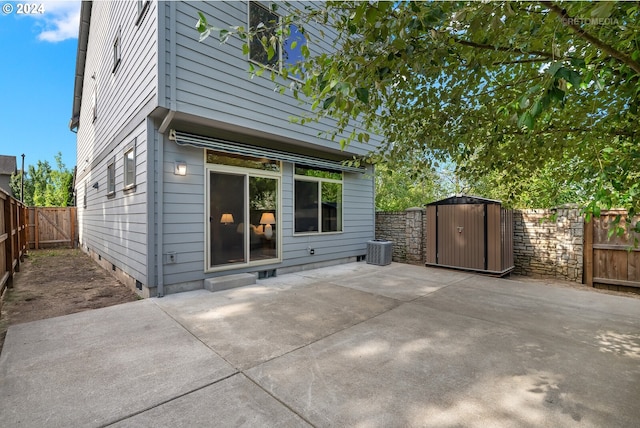 rear view of house with central air condition unit, a patio, and a storage unit