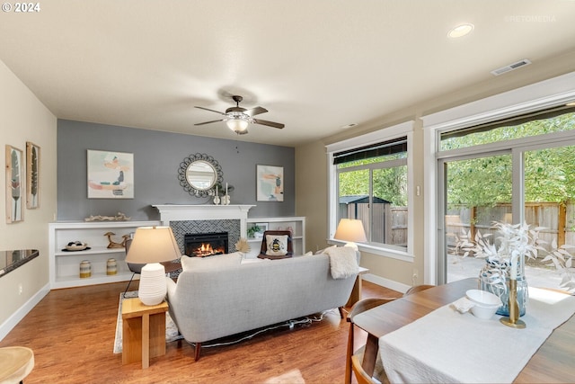 living room featuring hardwood / wood-style flooring, a fireplace, and ceiling fan