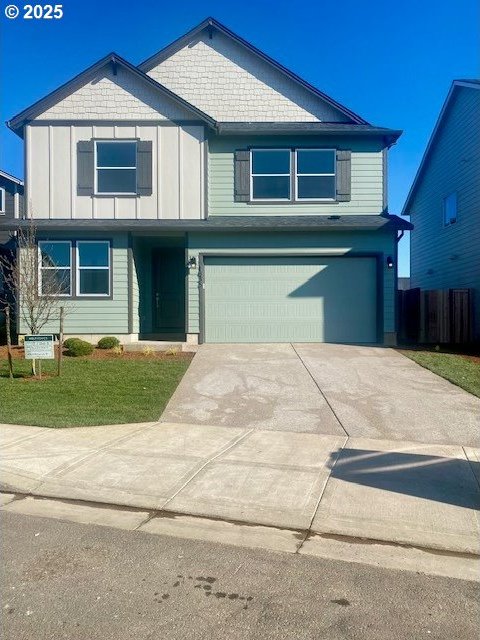 view of front of property featuring fence, a front lawn, driveway, and a garage