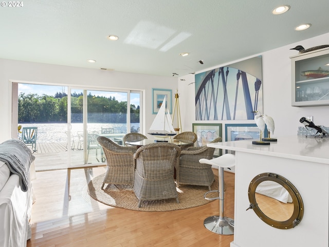 dining room featuring a water view and light wood-type flooring