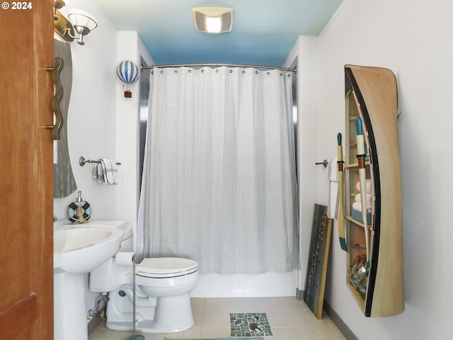 bathroom featuring toilet, tile flooring, and shower / tub combo with curtain