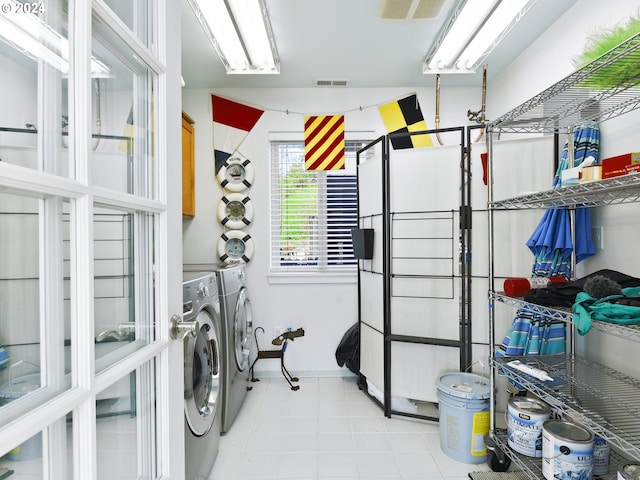 washroom with separate washer and dryer and light tile floors