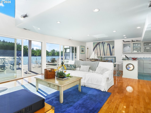 living room featuring a water view and light wood-type flooring