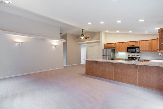 kitchen featuring kitchen peninsula, stainless steel appliances, lofted ceiling, and light colored carpet