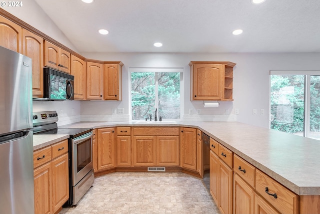 kitchen featuring black appliances, kitchen peninsula, a wealth of natural light, and sink