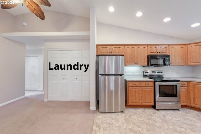 kitchen featuring stainless steel appliances, lofted ceiling, and light carpet