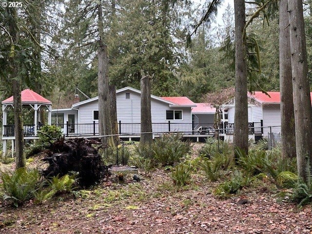 view of property exterior with a wooden deck and a gazebo