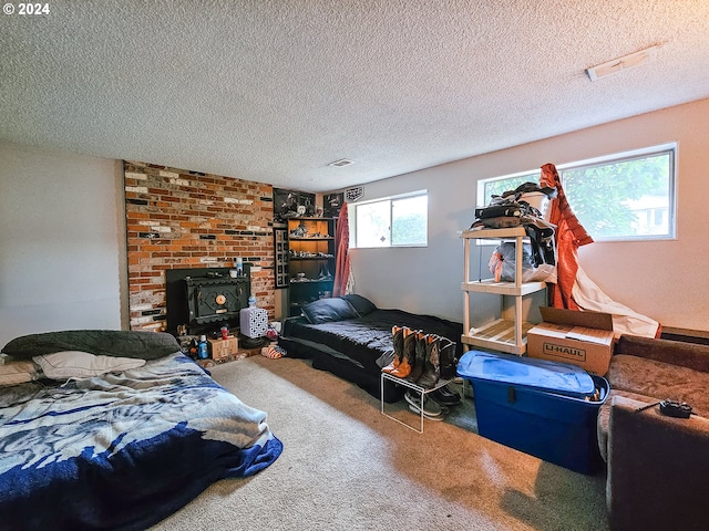 carpeted bedroom featuring a wood stove, brick wall, a brick fireplace, and a textured ceiling