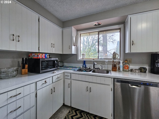 kitchen with sink, a textured ceiling, white cabinetry, and stainless steel dishwasher