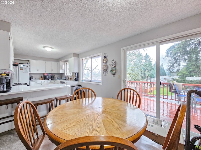 tiled dining room featuring a textured ceiling