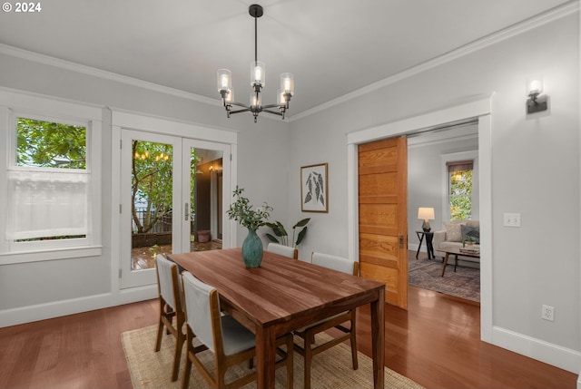 dining space with a notable chandelier, ornamental molding, and wood-type flooring