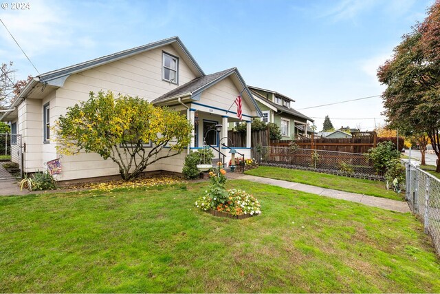 bungalow-style house featuring covered porch and a front yard