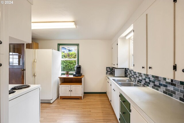 kitchen with white appliances, white cabinetry, sink, light wood-type flooring, and backsplash