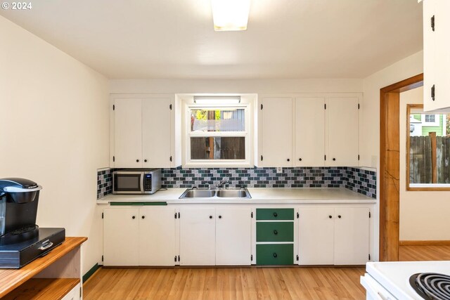 kitchen with backsplash, sink, white appliances, and white cabinets