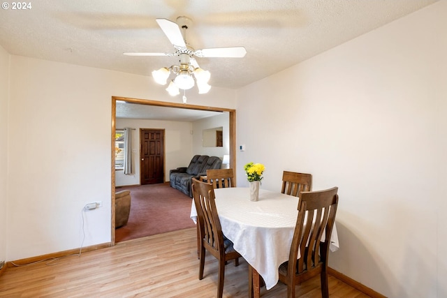 dining room featuring a textured ceiling, light hardwood / wood-style flooring, and ceiling fan