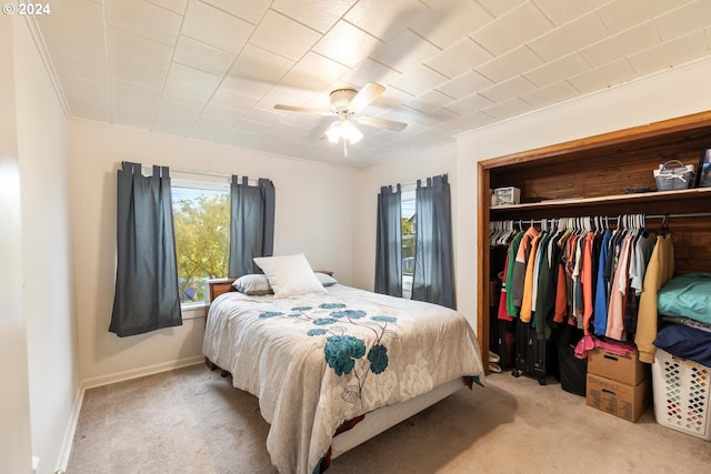 bedroom with a closet, ceiling fan, carpet flooring, and multiple windows