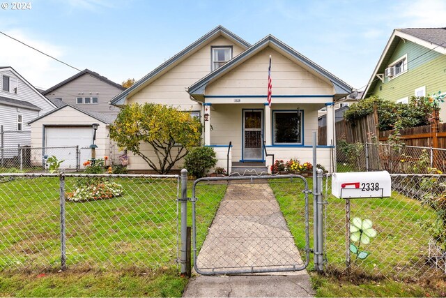 bungalow featuring covered porch and a front yard