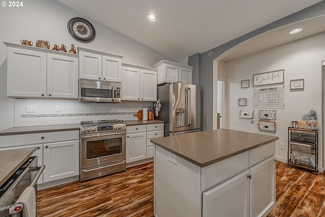 1843 Shelley Rd, Coquille, OR 97423 - kitchen featuring stainless steel appliances, vaulted ceiling, arched walkways, dark countertops, and dark wood finished floors