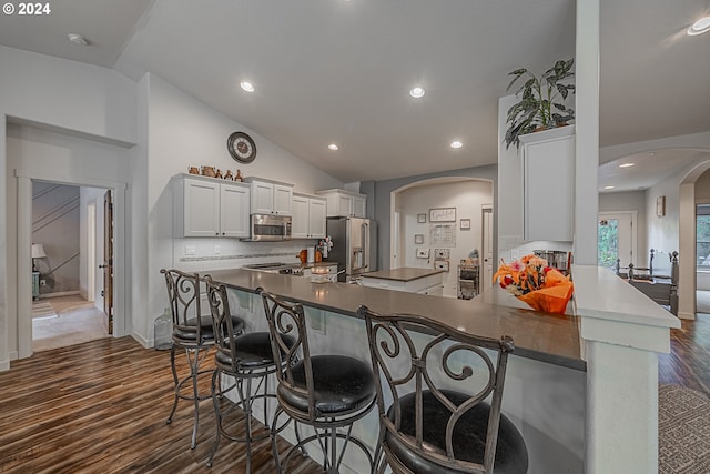 1843 Shelley Rd, Coquille, OR 97423 - kitchen featuring stainless steel appliances, arched walkways, dark countertops, dark wood finished floors, and tasteful backsplash