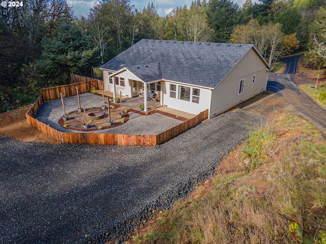 1843 Shelley Rd, Coquille, OR 97423 - view of front of home with a shingled roof, a patio, gravel driveway, and a wooded view