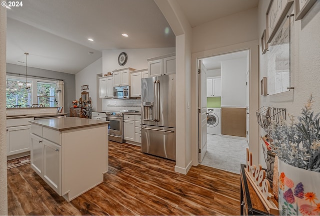 1843 Shelley Rd, Coquille, OR 97423 - kitchen with appliances with stainless steel finishes, washer / clothes dryer, dark wood-style flooring, a center island, and vaulted ceiling
