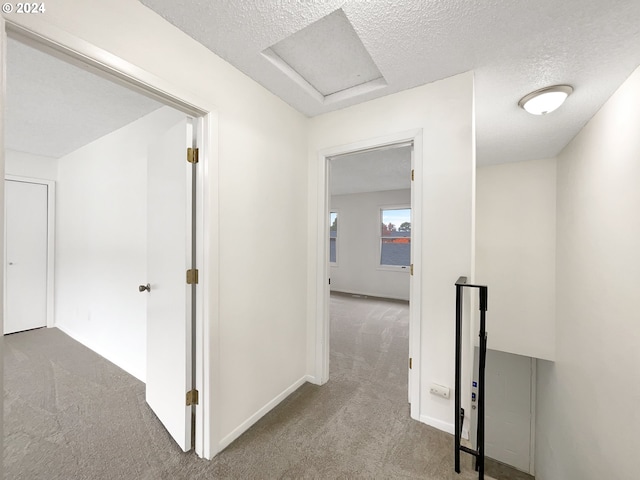 hallway featuring a textured ceiling and carpet floors