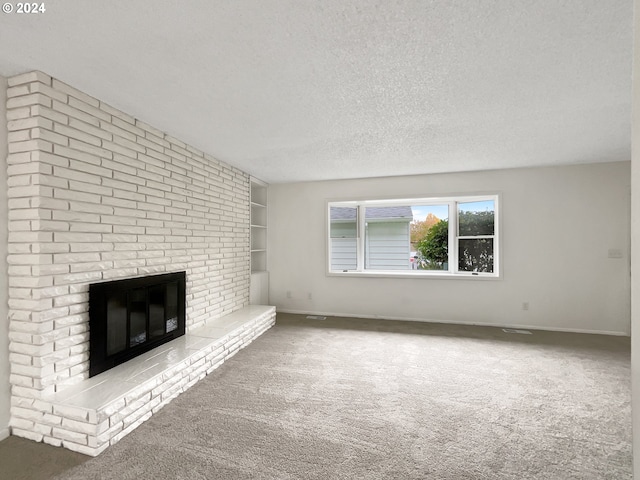 unfurnished living room with a brick fireplace, carpet, and a textured ceiling