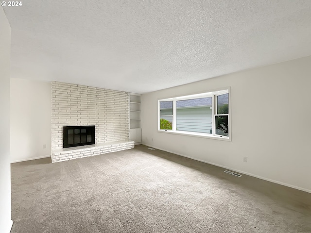 unfurnished living room featuring a brick fireplace, a textured ceiling, and carpet