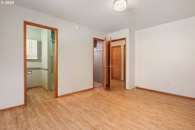 unfurnished bedroom with a textured ceiling and light hardwood / wood-style floors