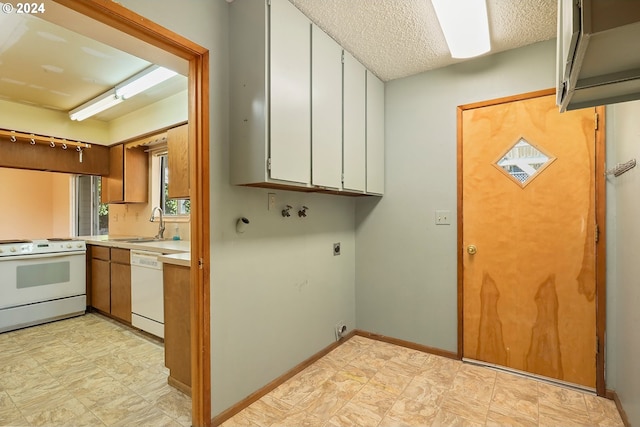 kitchen with white cabinetry, white appliances, sink, and a textured ceiling