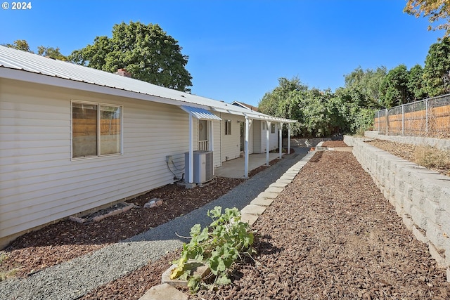 view of property exterior featuring central AC unit and a patio area