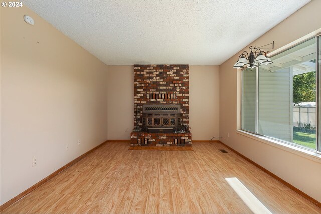 unfurnished living room with a chandelier, hardwood / wood-style floors, and a textured ceiling