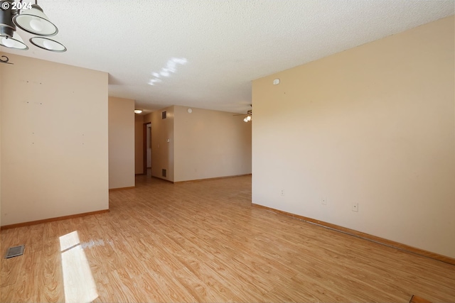 unfurnished room with ceiling fan, light hardwood / wood-style floors, and a textured ceiling