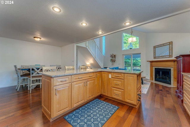 kitchen featuring hanging light fixtures, lofted ceiling, a center island, and dark hardwood / wood-style floors