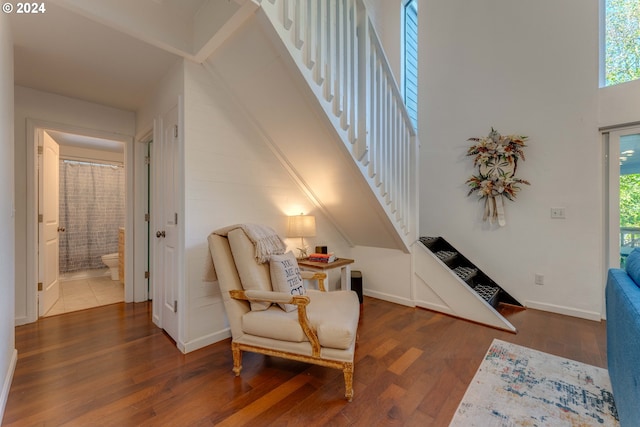 living area with dark wood-type flooring and a high ceiling