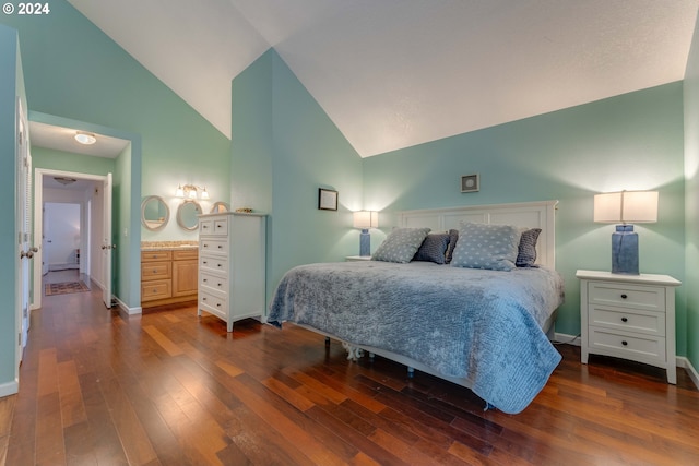 bedroom featuring connected bathroom, dark hardwood / wood-style floors, and high vaulted ceiling