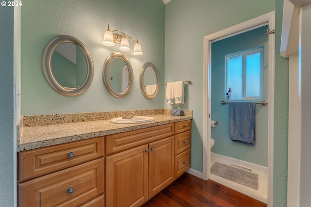 bathroom with vanity, hardwood / wood-style floors, and toilet