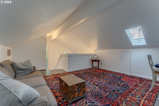 living room featuring a textured ceiling, vaulted ceiling with skylight, and carpet flooring