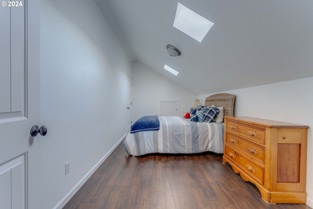 bedroom featuring vaulted ceiling with skylight and dark hardwood / wood-style flooring