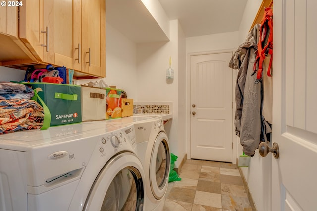 clothes washing area featuring separate washer and dryer and cabinets