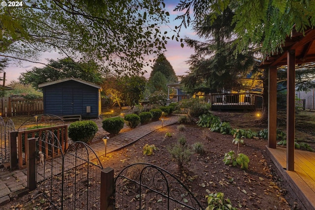 yard at dusk with a deck and a storage unit